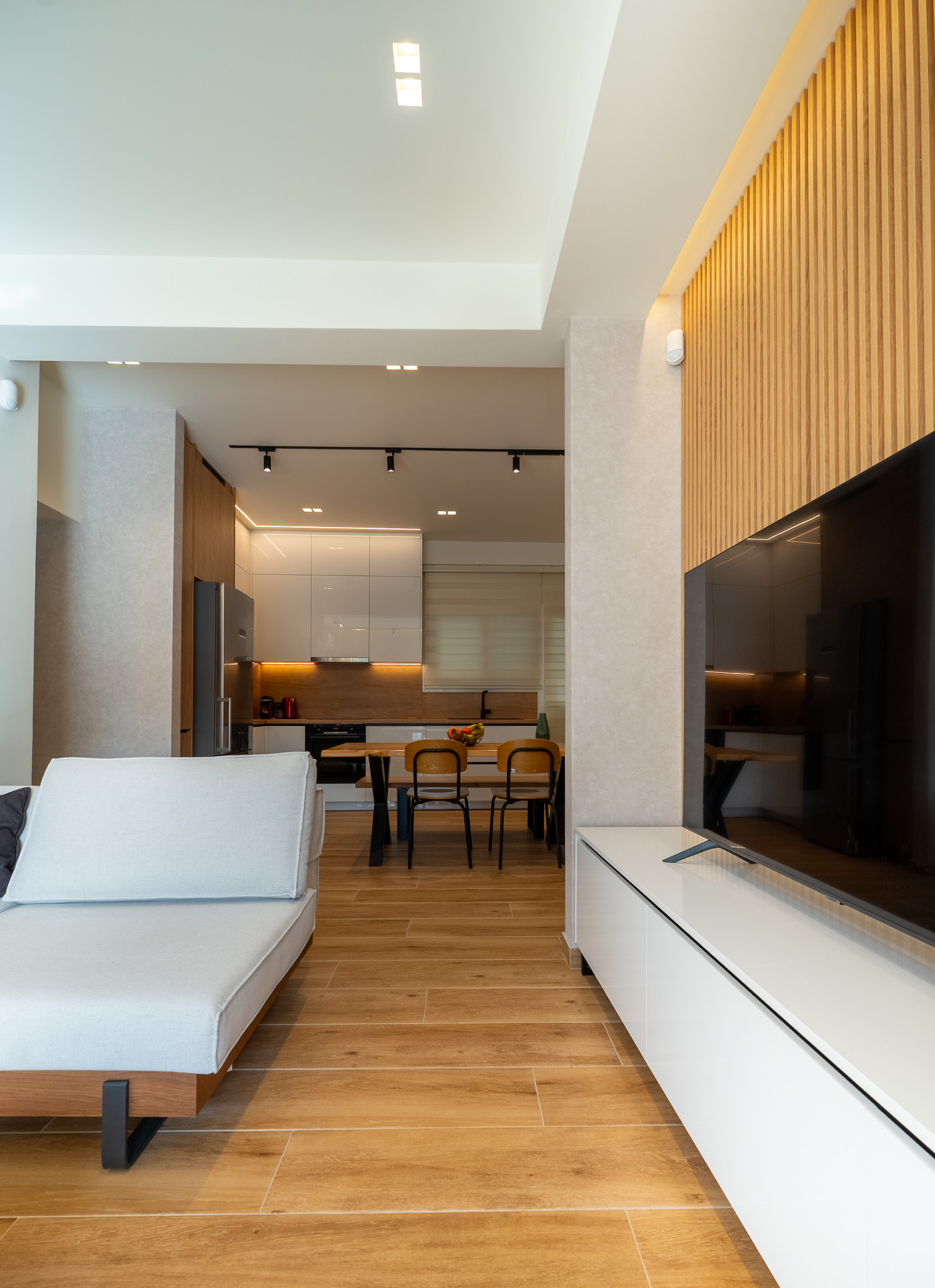 A&K Chorothetisis, portrait living-to-kitchen vista with white daybed and slatted TV wall