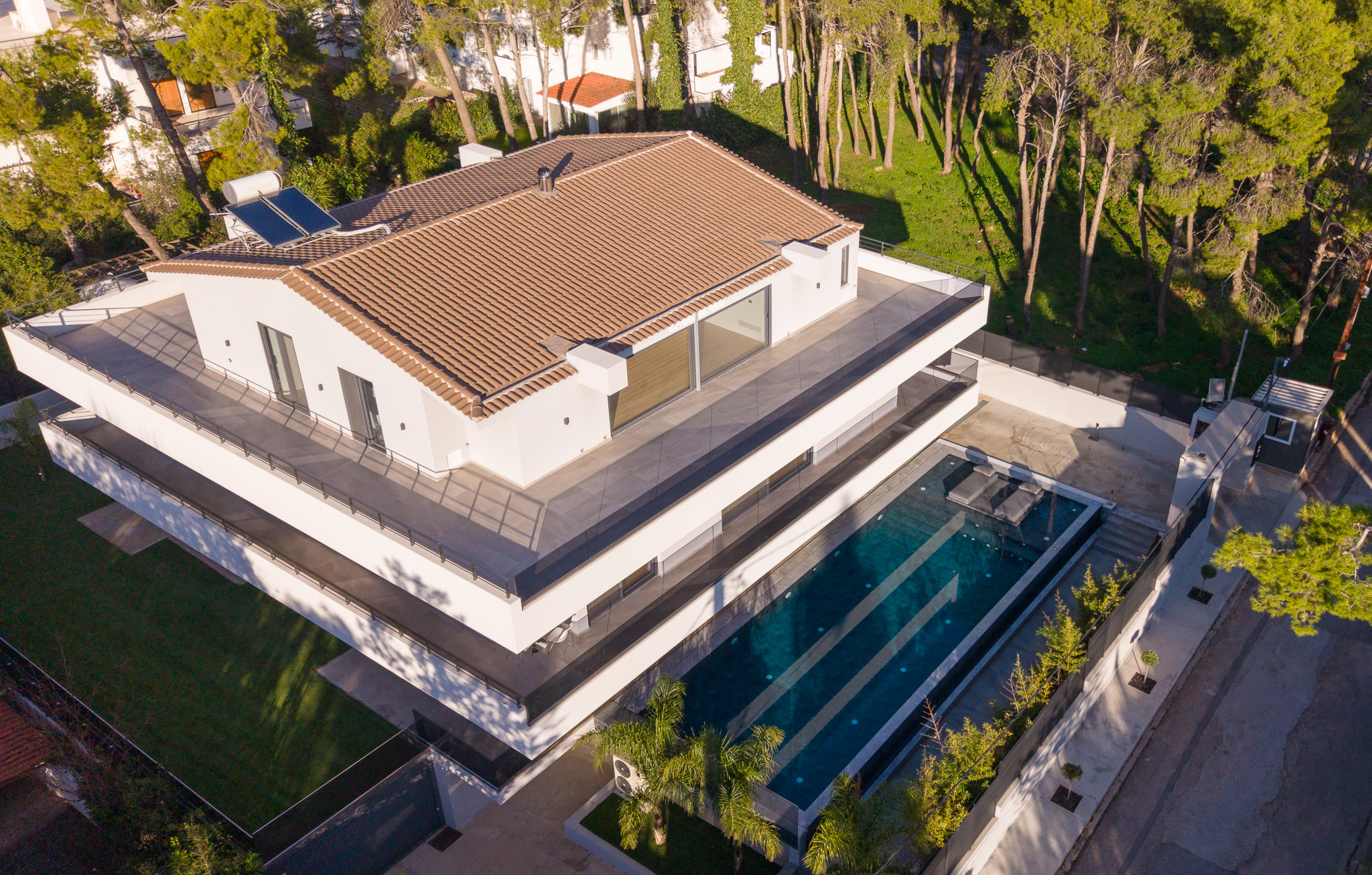 Villa Bond, side aerial of roof, pool and driveway with pines on three sides